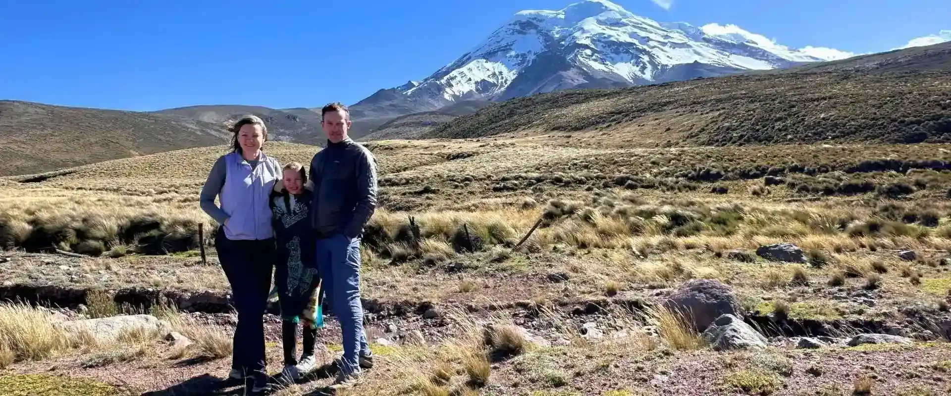 Familia en el páramo con el volcán Chimborazo nevado al fondo