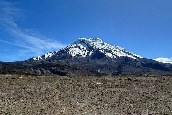 El volcán Chimborazo nevado sobre el arenal en un día despejado