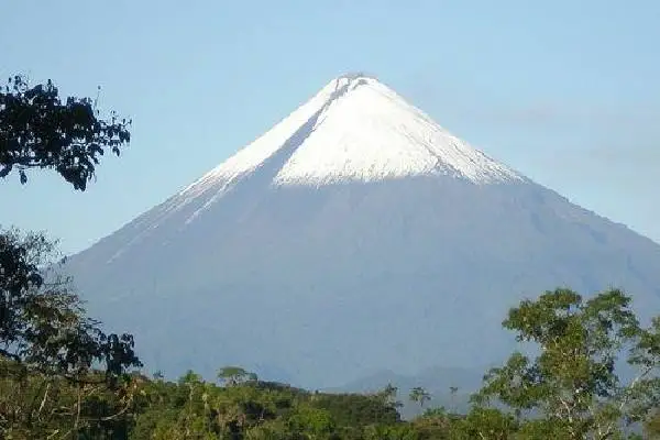 Cono nevado del volcán Sangay rodeado de vegetación amazónica