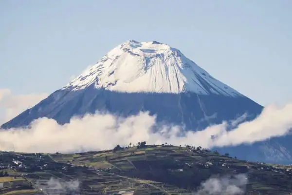 Volcán Tungurahua con nubes en la base y cumbre nevada