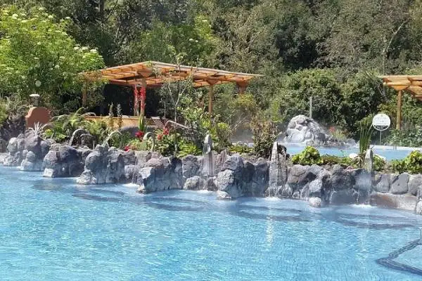 Steaming thermal pools surrounded by stone walls and gardens at the Papallacta hot springs spa