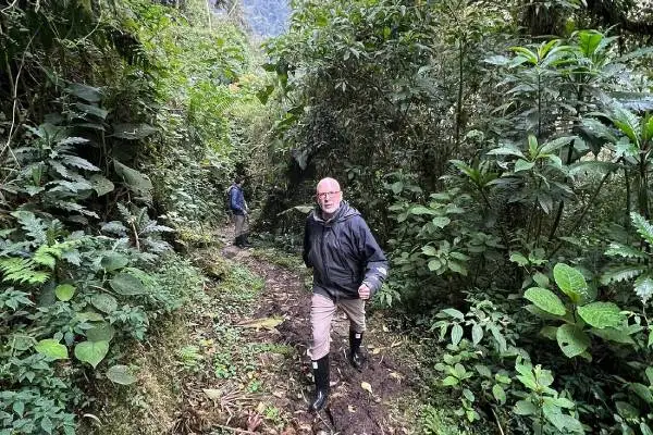 Hikers walking a muddy cloud forest trail near Papallacta in the Ecuadorian Andes