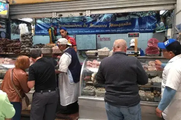 Mercado Iñaquito: clientes comprando en un puesto de mariscos, en el norte de Quito