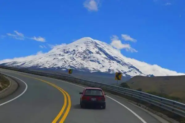 Auto por la carretera de montaña hacia la cumbre nevada del volcán Chimborazo