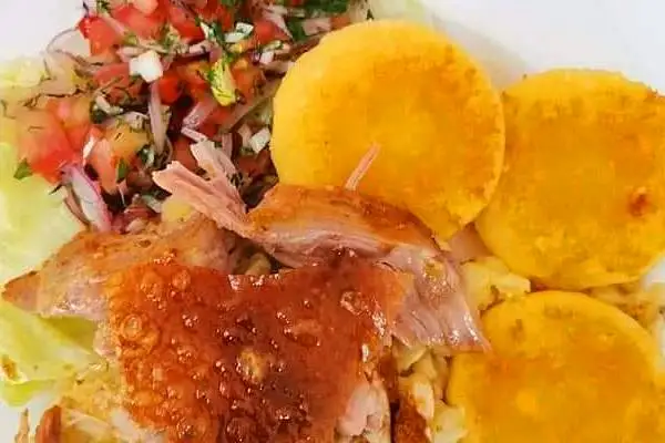Plato de hornado con mote, ensalada y llapingachos, comida típica de Riobamba