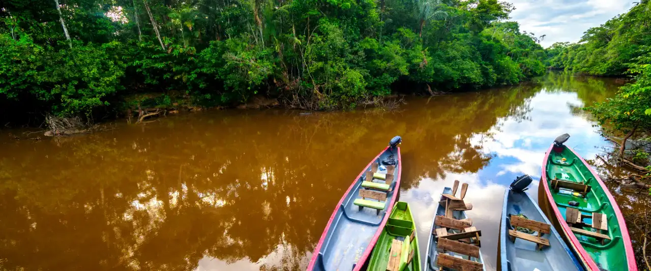 Colorful canoes on a rainforest river near Tena in the Ecuadorian Amazon