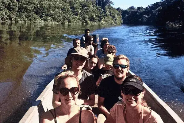 Tourists smiling in a canoe on a Cuyabeno Reserve river excursion