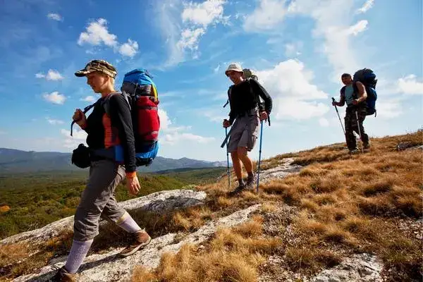 Trekkers crossing dry highland grassland on the Chugchilan trail