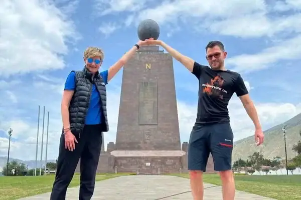Travelers posing at the Middle of the World monument marking the equator near Quito
