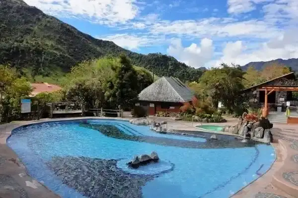 Outdoor thermal pools at Papallacta hot springs framed by green mountains
