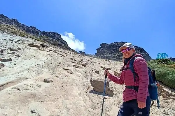 Woman hiking the rocky volcanic slope of Rucu Pichincha