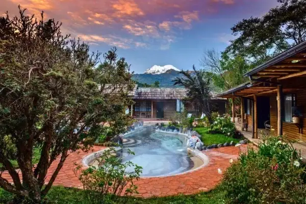 Termas de Papallacta pools at sunset with Antisana volcano in the background