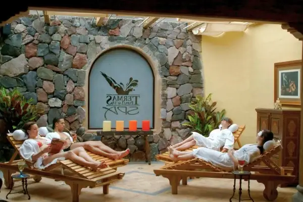 Guests in bathrobes relaxing on loungers at the Termas de Papallacta spa entrance
