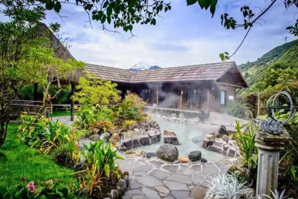 Outdoor thermal pool at Papallacta with steam and mountain views through the trees