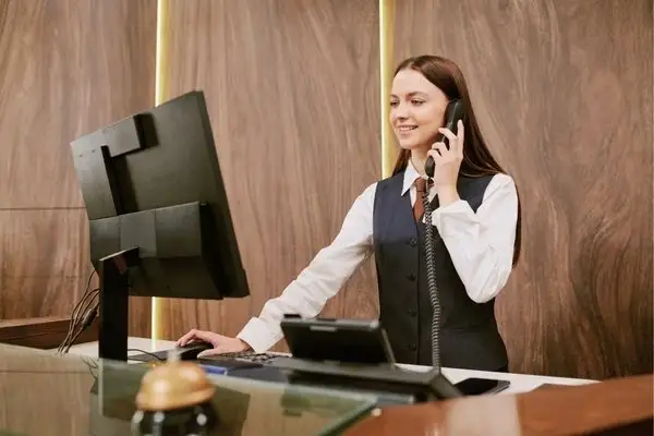 Hotel receptionist on the phone confirming an Amazon trip from Quito booking