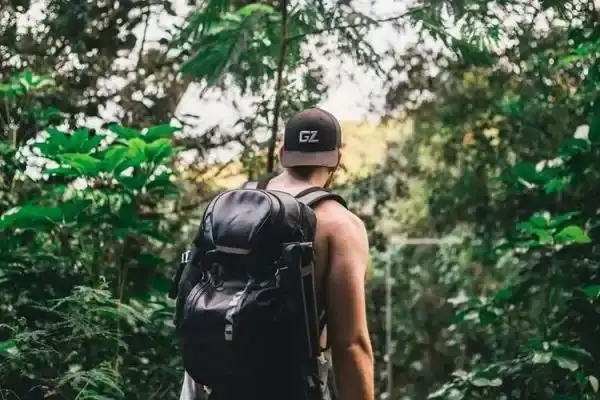 Hiker with backpack walking a jungle trail in the Ecuadorian Amazon