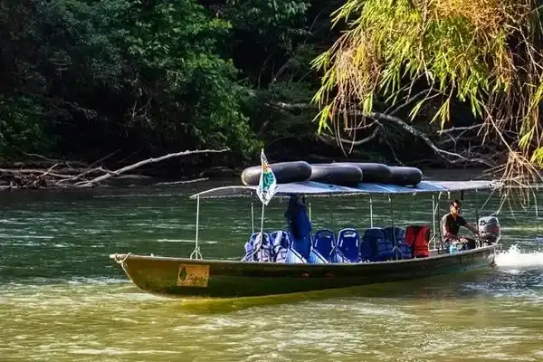 Covered motorized canoe with life vests crossing an Amazon river
