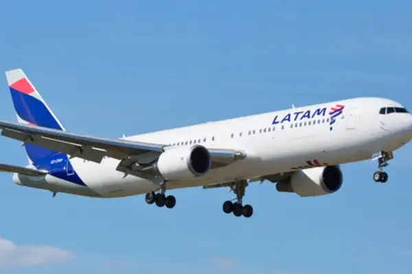 LATAM airplane climbing into a blue sky after departing Quito