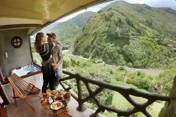 Couple enjoying a hot tub and breakfast on a mountain-view balcony in Banos