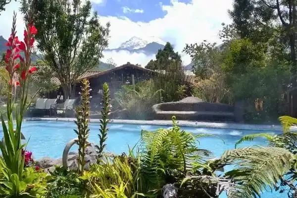 Papallacta thermal pool with a snow-capped Andean volcano rising above the resort gardens