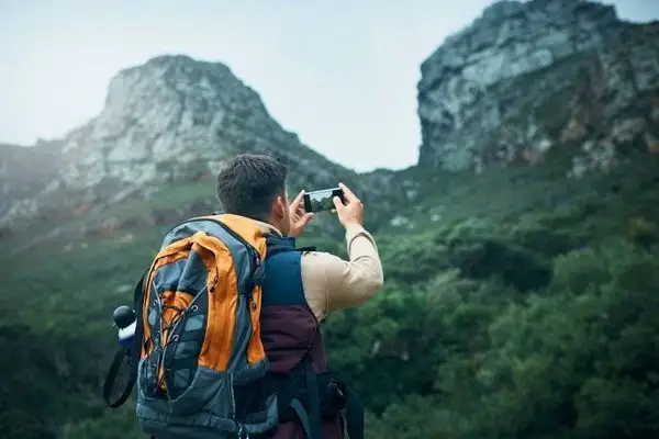 Hiker photographing lush green mountains near Mindo cloud forest