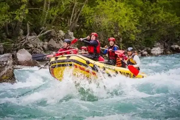 Rafters paddling through whitewater rapids on a banos day trip from Quito