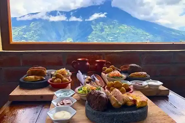 Traditional Ecuadorian lunch spread with Tungurahua volcano view in Banos