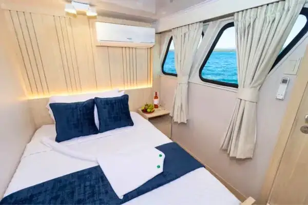 Double bed cabin with ocean-view windows aboard a Galapagos cruise