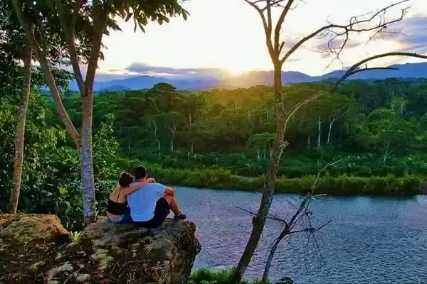 Couple watching the sunset over the Amazon river from a rocky lookout