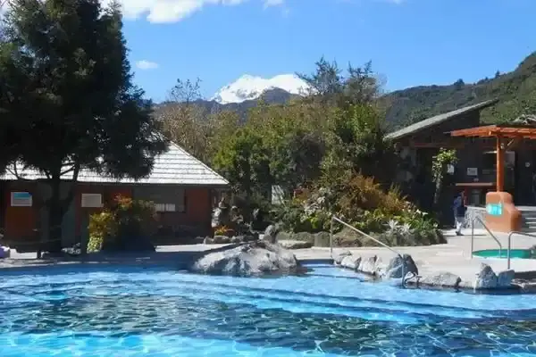 Visitor in Ecuador hot springs reading travel guide