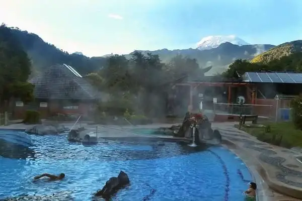 Steaming outdoor thermal pool at Papallacta hot springs with the Antisana volcano in the background