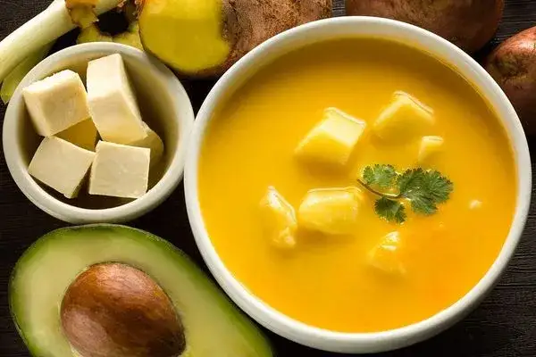 Typical Ecuadorian food from the Sierra: locro de papas potato soup with cheese and avocado