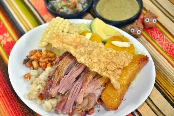 Roasted pork named Hornado with corn and salad