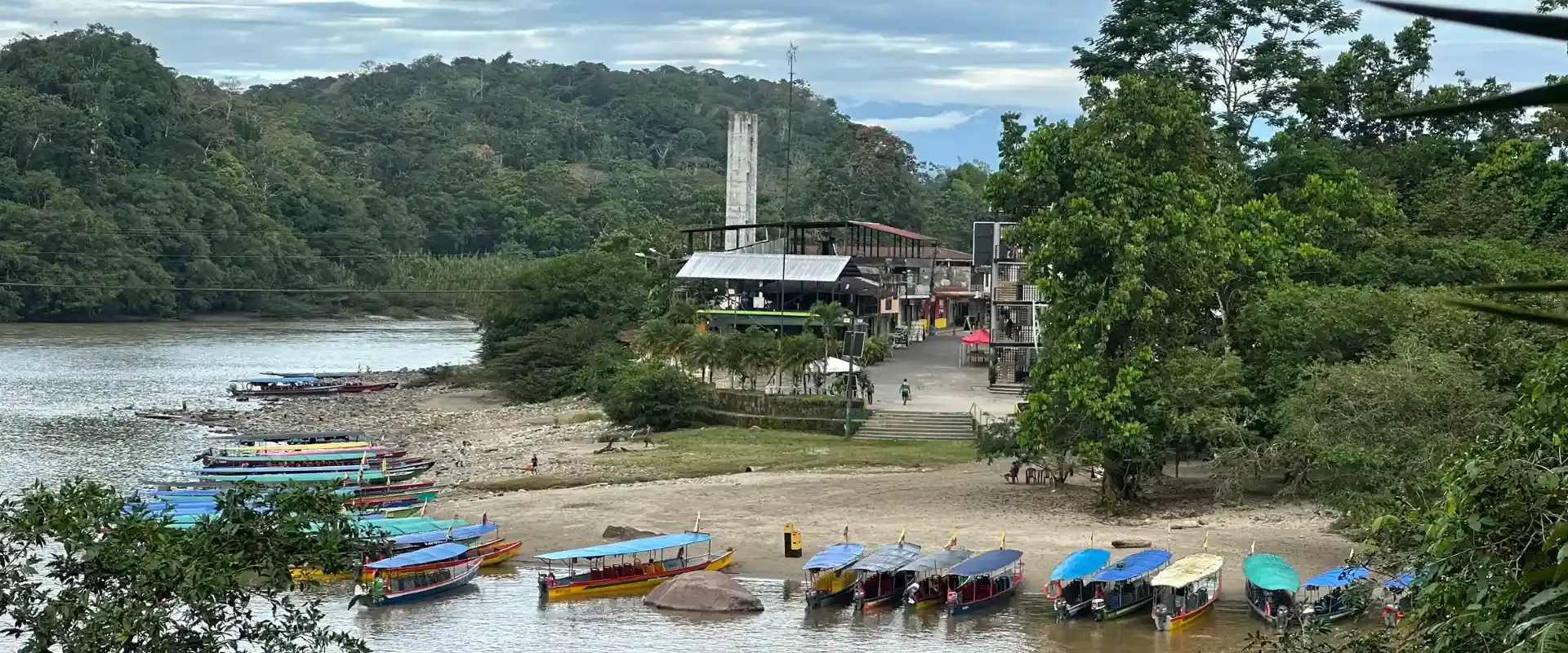 Motorised wooden canoes lined up on the river beach at the Amazon port near Tena Ecuador